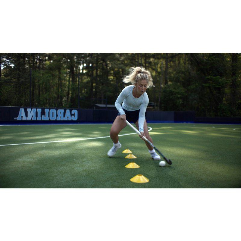 Katie Dixon doing field hockey drills on a practice field.