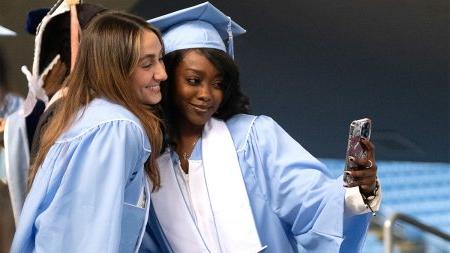 Two female students taking a selfie together at U.N.C. Chapel Hill's Winter Commencement.